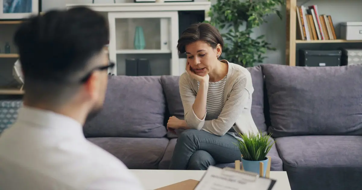 Una persona conversando con un consejero durante una sesión de terapia, un momento clave para dejar el cristal